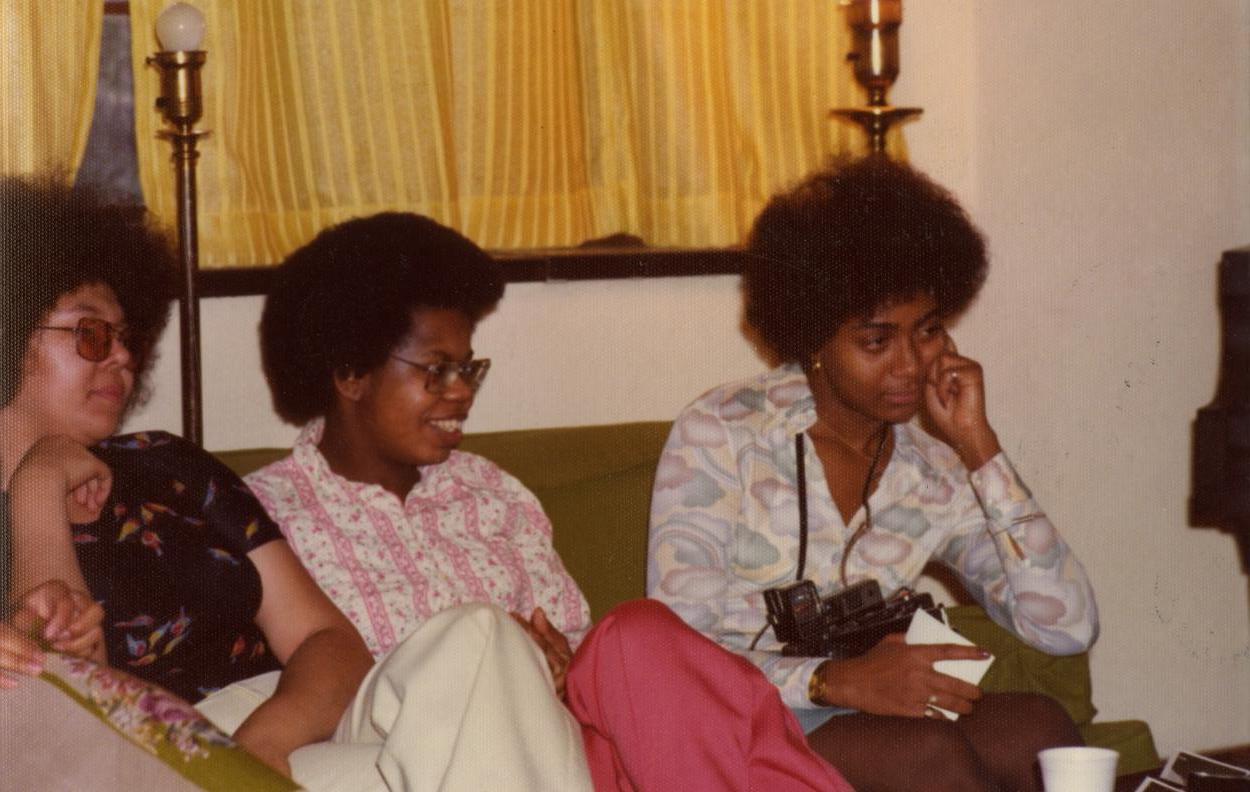Three Black students sit on a couch in Perry House.