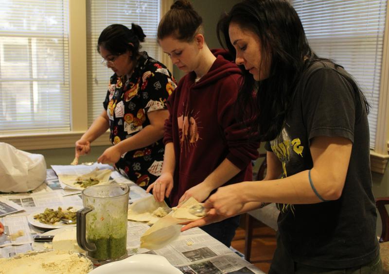 移民360°学生在SGA厨房里做玉米粉蒸肉.