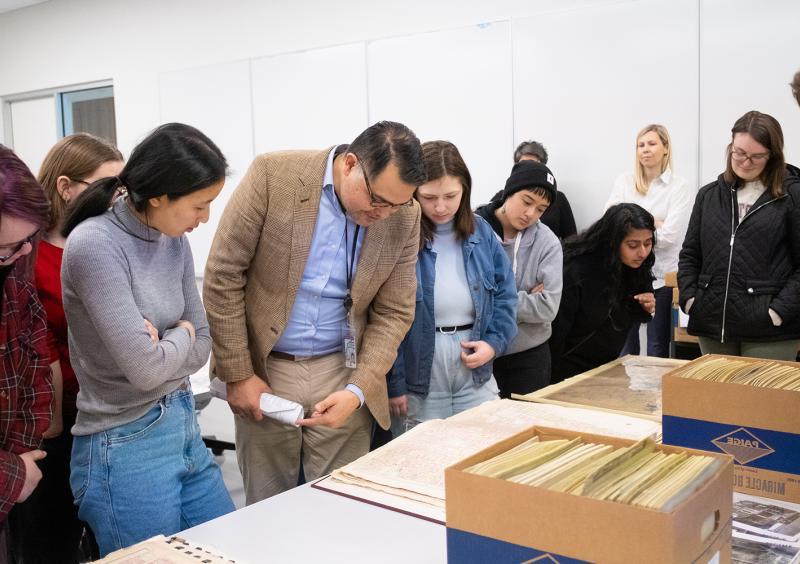 学生在“费城马赛克”中与图书管理员一起观看天普大学城市档案馆的材料 