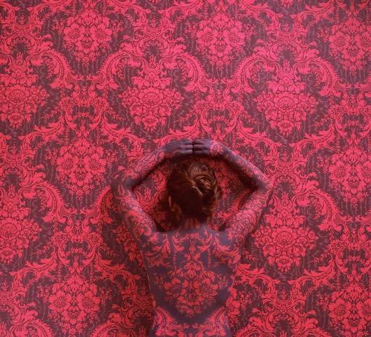 塞西莉亚·帕雷德斯(Cecilia Paredes)的画与她高举双臂的华丽红色背景相匹配