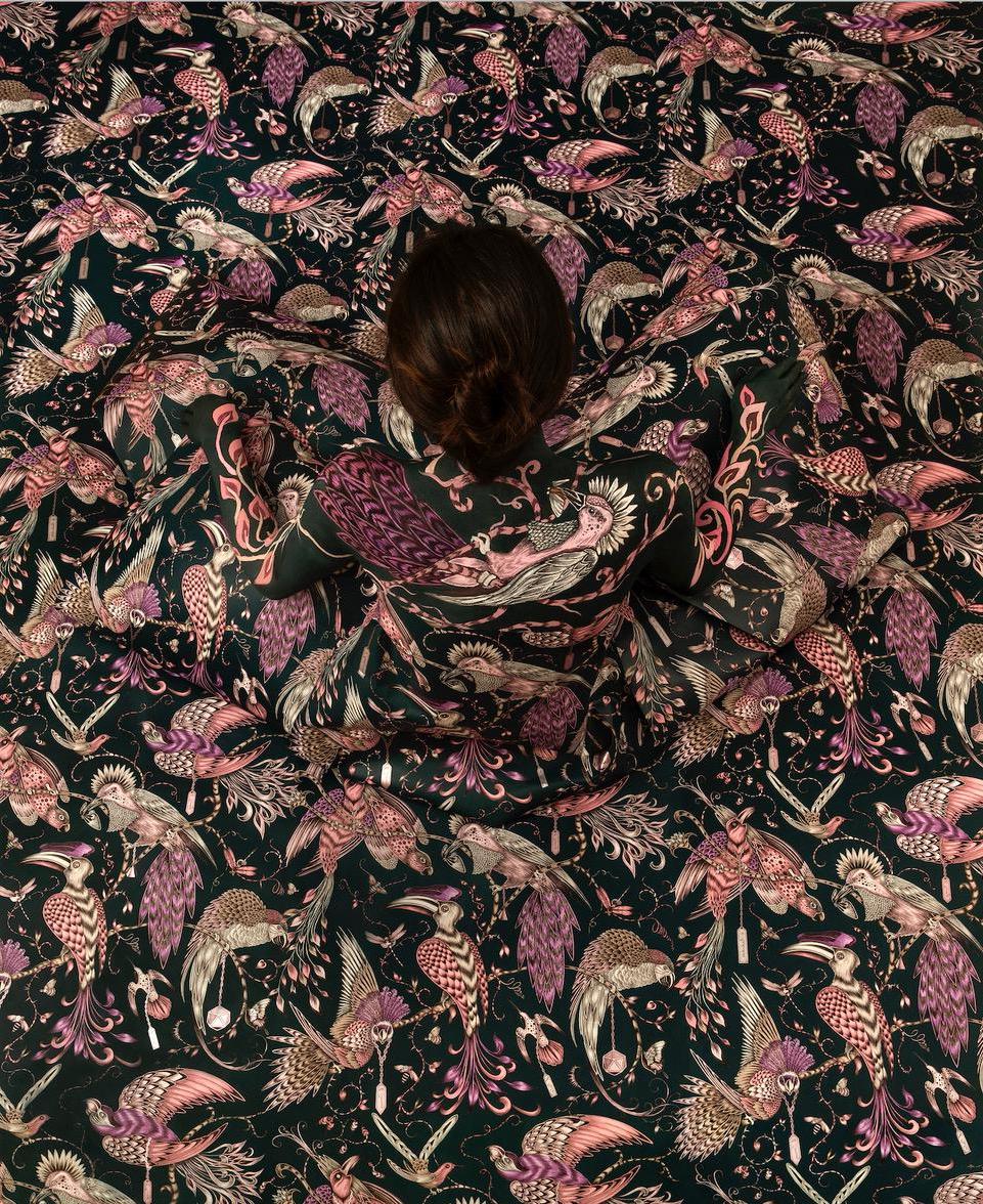 Cecilia Paredes从上方拍摄, 坐在以动植物图案填充背景的裙子中.