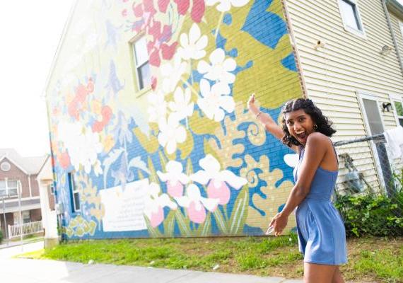 25岁的Lakshmi Natesan在费城壁画艺术公司的花卉壁画前摆姿势