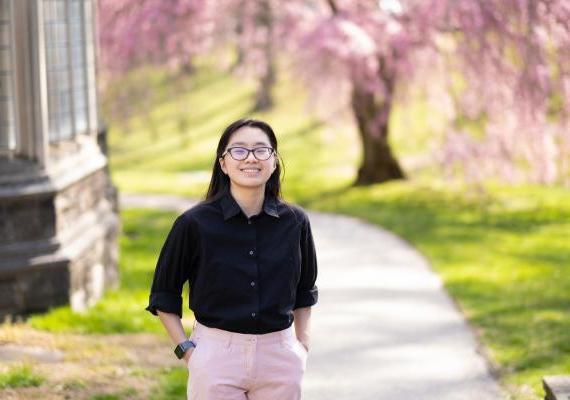 Glory Zhang in front of cherry blossom tree