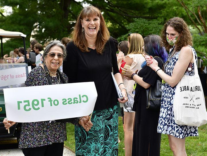 Liela standing with Kim Cassidy at Reunion 2022, holding a "Class of 1951" banner