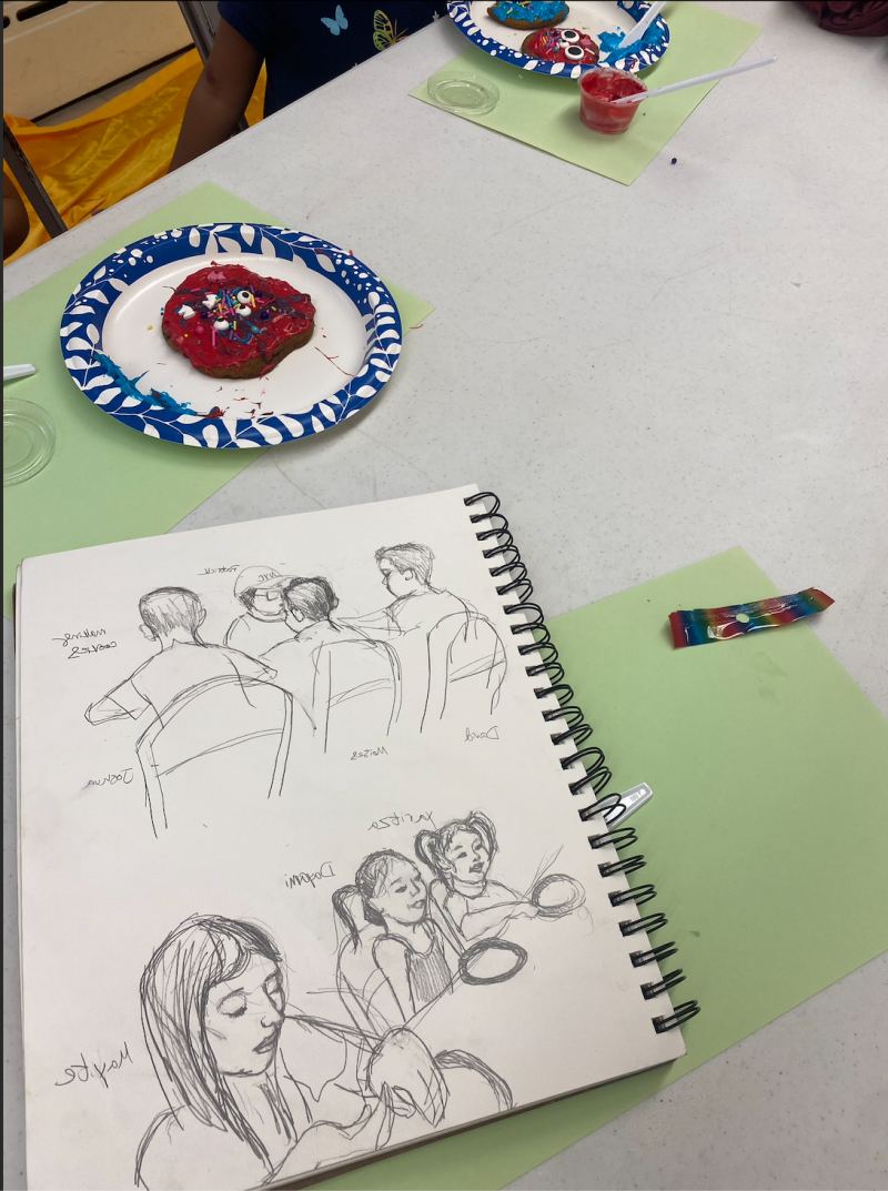 Notebook with drawings and a plate with a cookie. 
